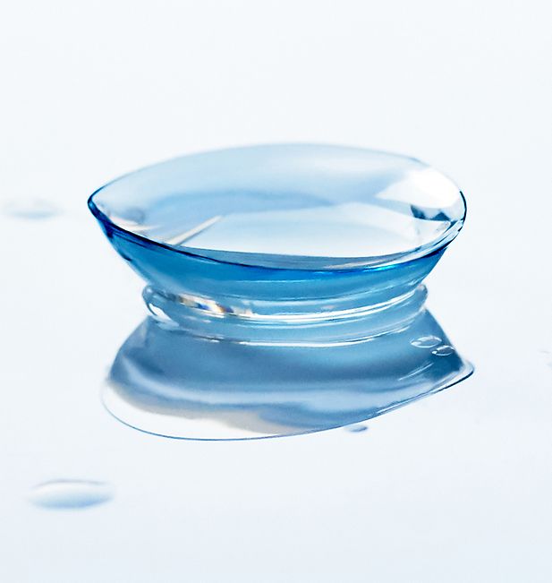 Zwei befeuchtete Kontaktlinsen, umgeben von Wassertropfen