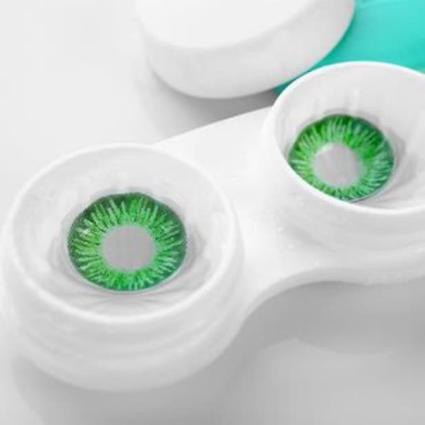 Zwei grüne Farblinsen in einem Kontaktlinsenbehälter