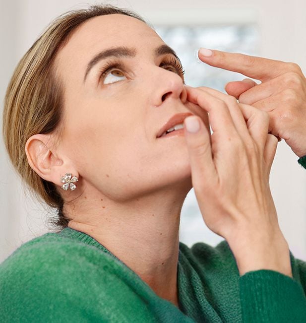 Mann füllt Kontaktlinsenbehälter mit Flüssigkeit 