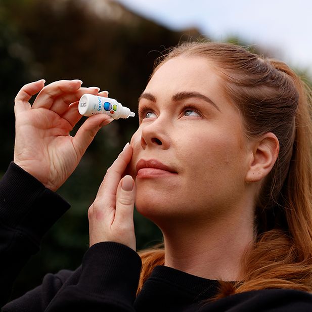 Frau benutzt Augentropfen draußen